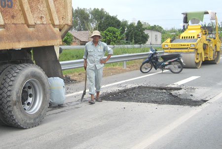 Công nhân đang sửa chữa các điểm hư hỏng trên tuyến đường nối Vị Thanh - TP Cần Thơ