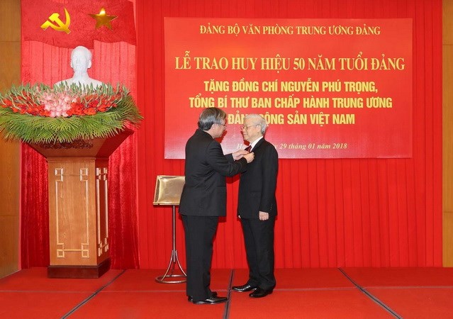 Ủy viên Bộ Chính trị, Thành viên Thường trực Ban Bí thư, Chủ nhiệm Ủy ban Kiểm tra Trung ương Trần Quốc Vượng gắn Huy hiệu 50 năm tuổi Đảng cho Tổng Bí thư Ban Chấp hành Trung ương Đảng Cộng sản Việt Nam Nguyễn Phú Trọng