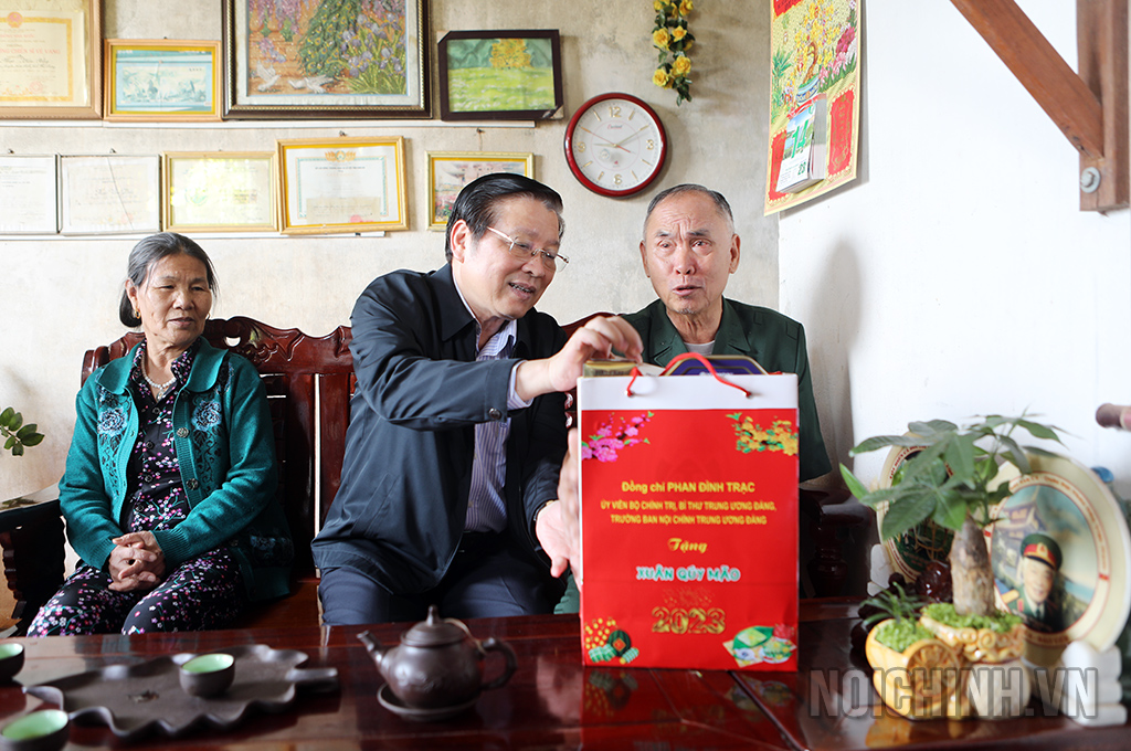 Đồng chí Phan Đình Trạc, Ủy viên Bộ Chính trị, Bí thư Trung ương Đảng, Trưởng Ban Nội chính Trung ương tặng quà cho thương binh hạng 2/4 Vũ Tự Nhiên, ở bon Bu Dăr