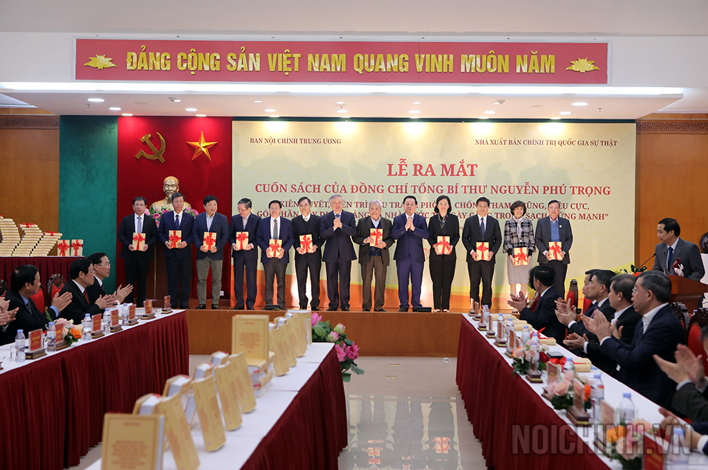 Đồng chí Nguyễn Hòa Bình, Ủy viên Bộ Chính trị, Bí thư Trung ương Đảng, Chánh án Tòa án nhân dân tối cao và đồng chí Nguyễn Trọng Nghĩa, Bí thư Trung ương Đảng, Trưởng Ban Tuyên giáo Trung ương trao sách tặng