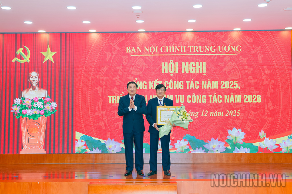 Đồng chí Phan Đình Trạc, Ủy viên Bộ Chính trị, Bí thư Trung ương Đảng, Trưởng Ban Nội chính Trung ương trao Huy hiệu 30 năm tuổi Đảng tặng đồng chí Phan Đức Sơn, Phó Vụ trưởng Vụ Tham mưu xử lý vụ án, vụ việc