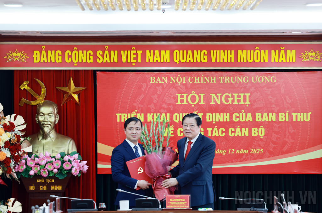 Đồng chí Phan Đình Trạc, Ủy viên Bộ Chính trị, Bí thư Trung ương Đảng, Trưởng Ban Nội chính Trung ương trao Quyết định và tặng hoa chúc mừng đồng chí Nguyễn Xuân Trường, Phó Trưởng Ban Nội chính Trung ương
