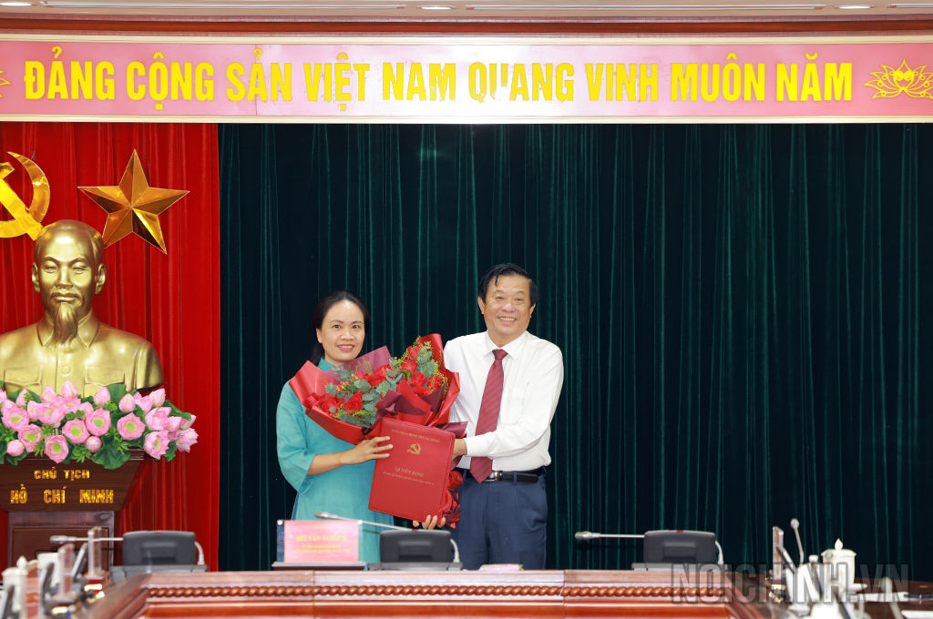 Đồng chí Bùi Văn Nghiêm, Ủy viên Trung ương Đảng, Phó Trưởng Ban Nội chính Trung ương trao Quyết định và tặng hoa chúc mừng đồng chí Trần Thị Hải Ninh